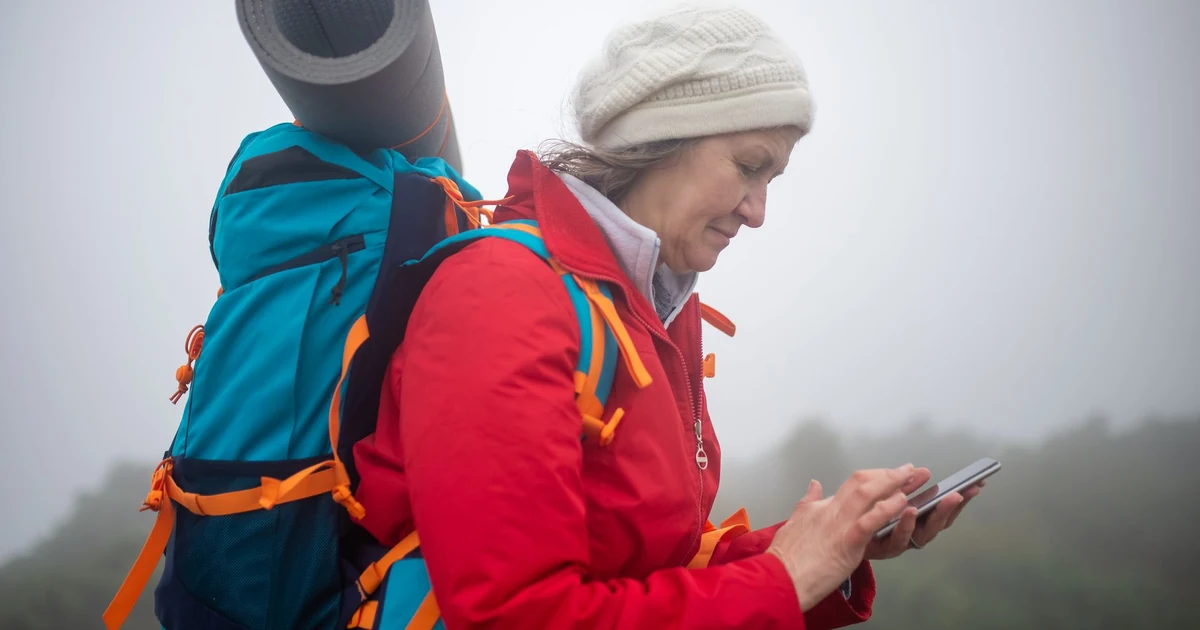 Femme voyageuse consultant son téléphone dans une ruelle ensoleillée