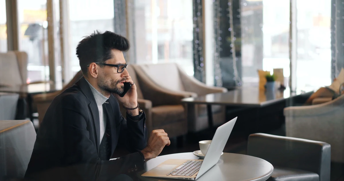 Laptop und Smartphone auf einem Café-Tisch beim Arbeiten