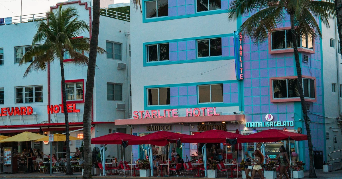 Avenida Ocean Drive com coqueiros e carros clássicos em Miami