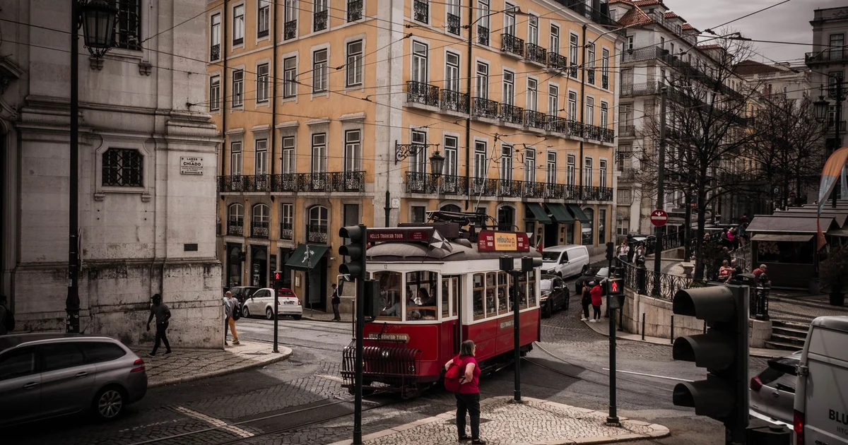 Bonde histórico amarelo circulando pelas ruas de Lisboa